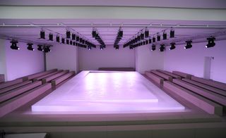 a tiered runway lit with pastel light. Block benches all the way around