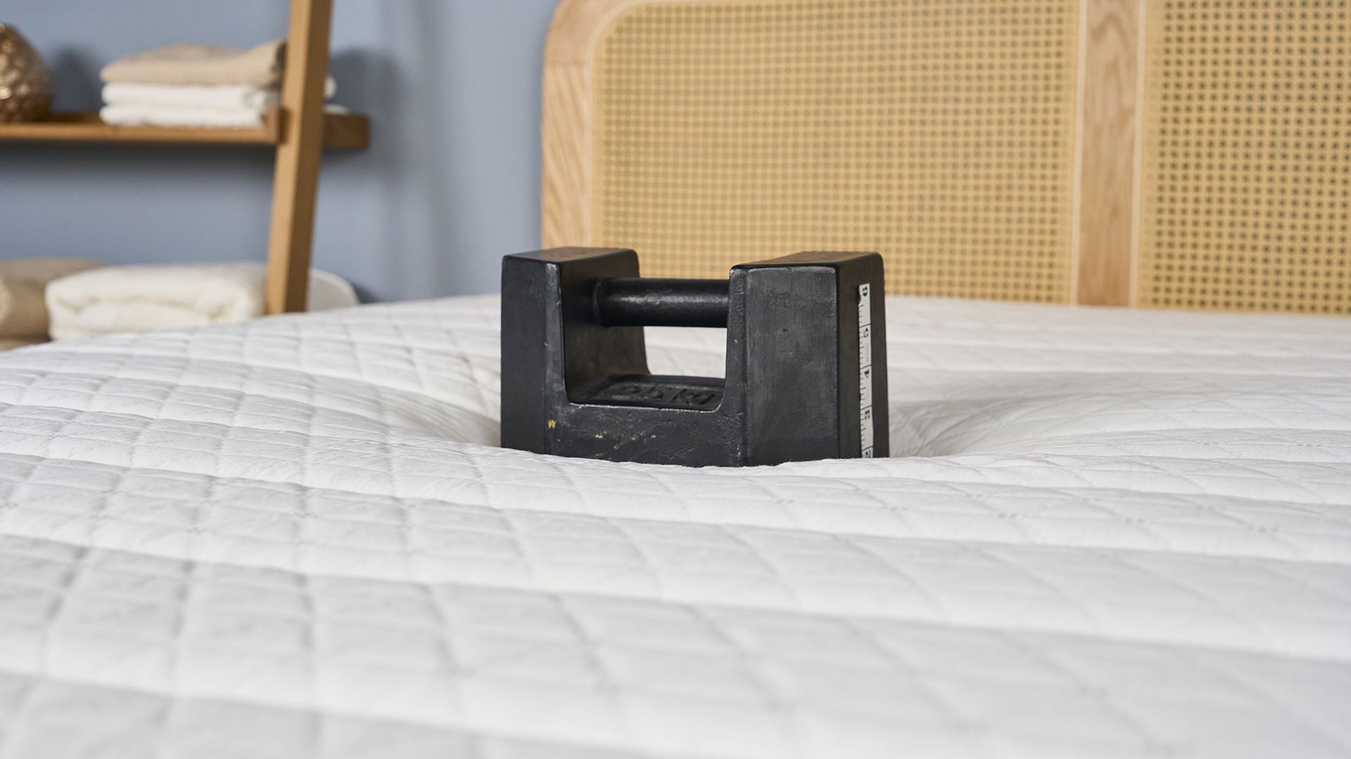 A close up of a 50lb weight balancing in the center of the Helix Dawn Mattress. It only sinks in around 1.5 to 2 inches, indicating a firmer feel