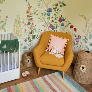 Nursery with flower mural and yellow armchair on patterned rug