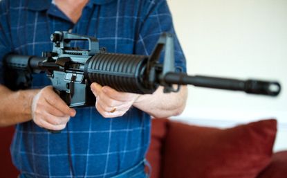 Man holding a Colt AR-15 assault rifle