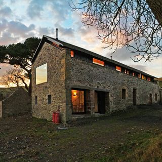 mill house with stone wall and grass lawn