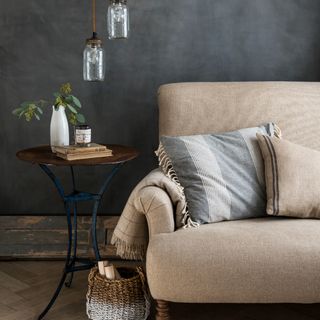 A living room with limestone-effect charcoal walls against a light beige linen sofa