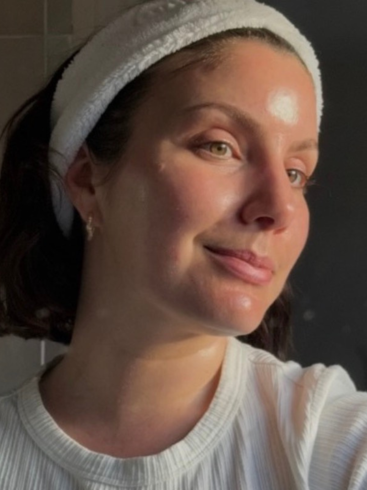 @emmahoareau with glowing skin wearing a headband and taking a picture in a mirror
