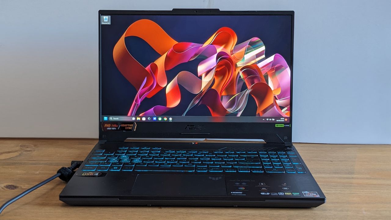 A black ASUS TUF Gaming A15 laptop on a wooden table