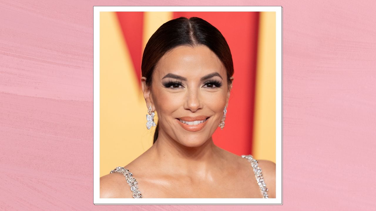 Image of Eva Longoria smiling with her hair in a low ponytail and wearing a silver crystal dress, on a pink background