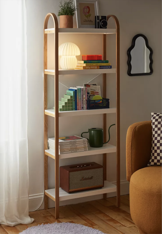 A bookcase with colorful decor on it next to a yellow seat