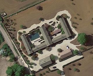 An overhead shot of the Beckham's home shows an E type structure with driveway and large surrounding fields