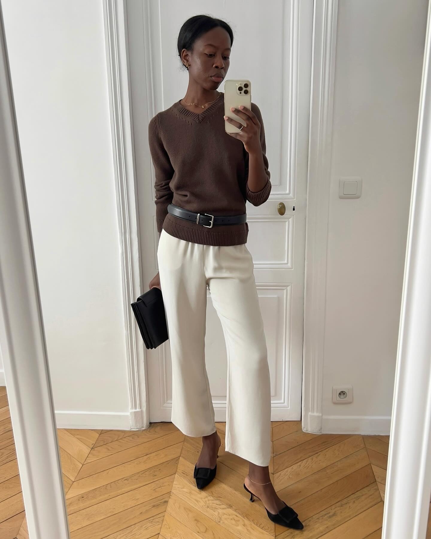 Influencer Sylvie Mus wearing a brown V-neck sweater and cream pants