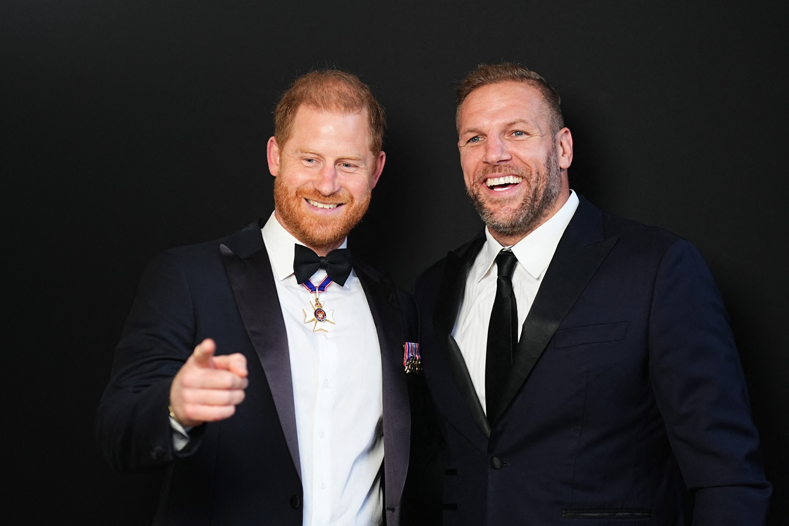 Prince Harry and James Haskell wearing suits and smiling