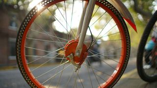 A orange rimmed bike wheel