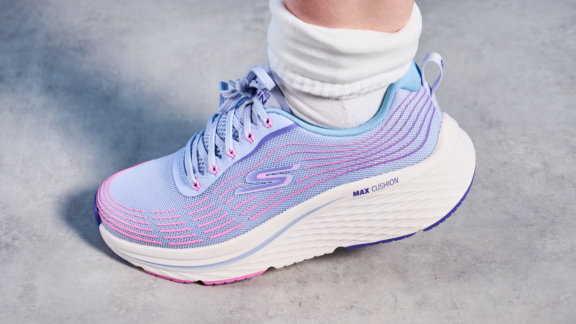 Skechers Max Cushioning Elite 2.0 running shoes photographed in front of a blue background.