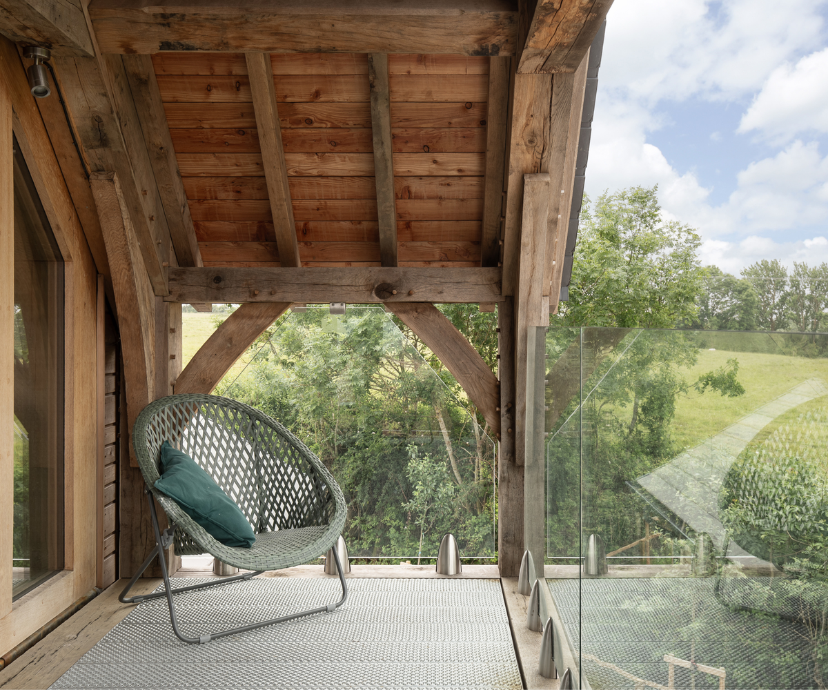 Glass balcony with a chair under wooden roof