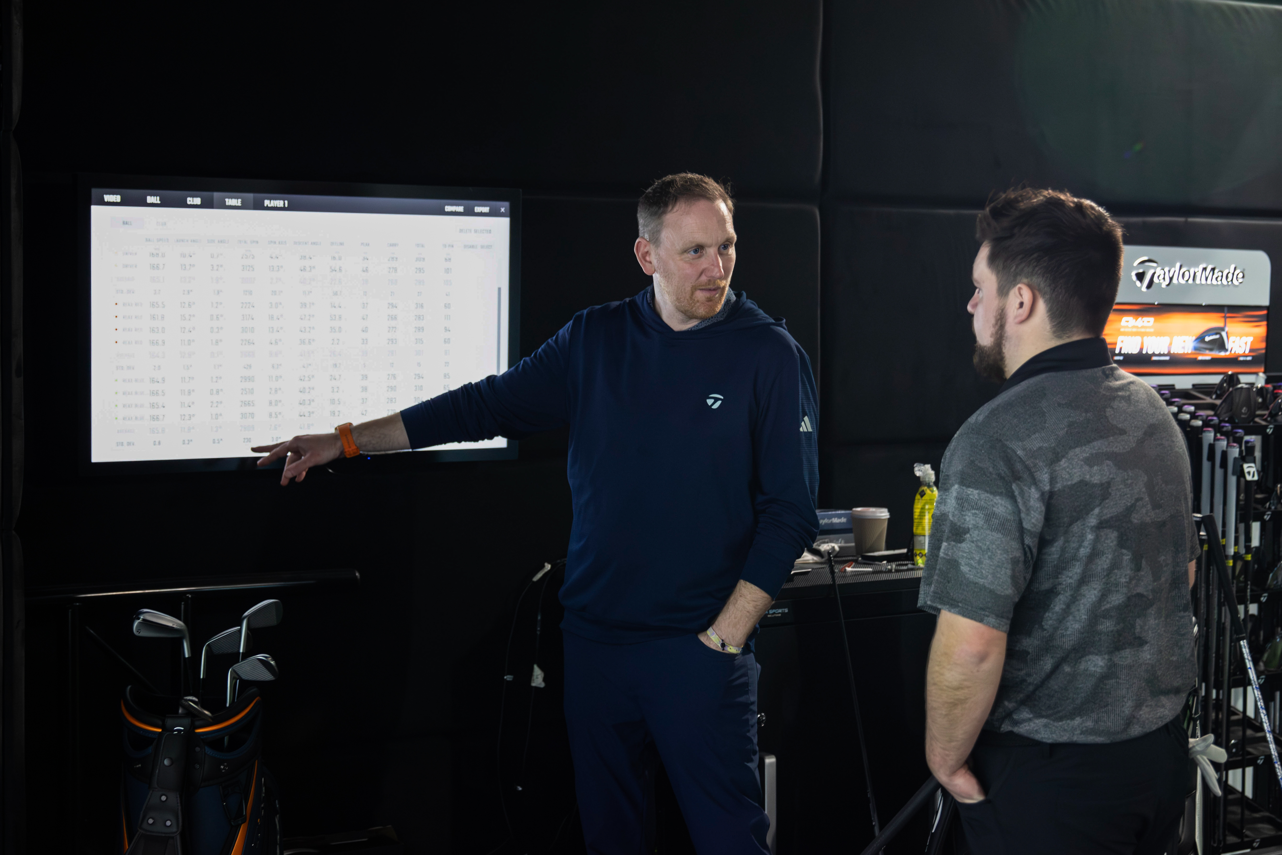 A golf fitter talks through numbers with a golfer during a fitting