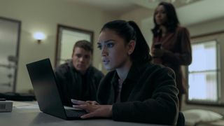 Rose works on a computer with Peter and Catherine behind her in The Night Agent season 2