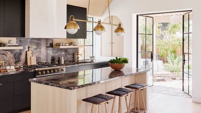 a modern kitchen with lighting over the island