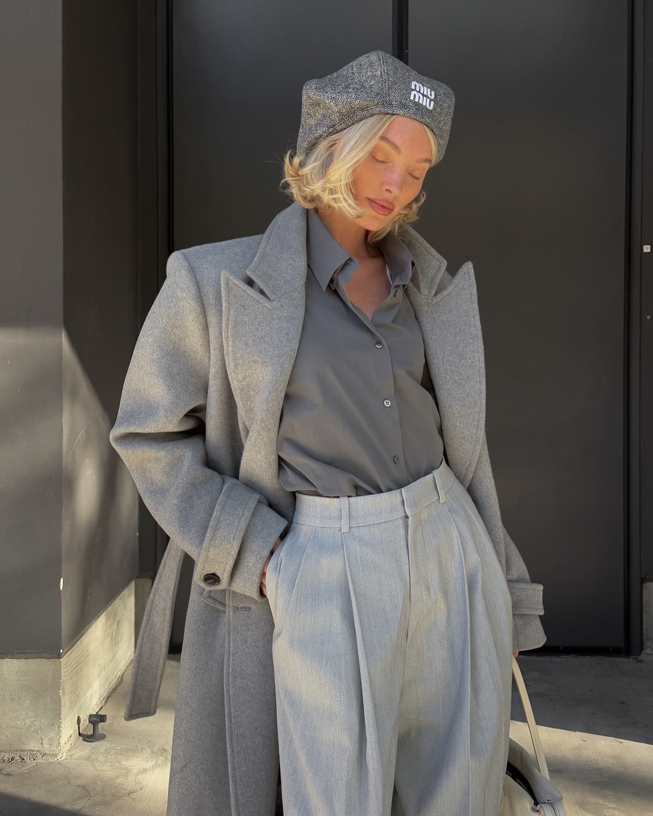 Elsa Hosk wearing an all grey outfit with a Miu Miu hat and a blonde bob hairstyle