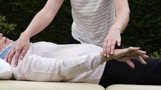 Person performs reiki on a patient