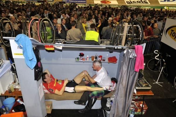 Bruno Risi is attended to by his soigneur as the party continues behind