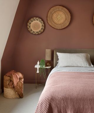 bedroom with dark red-pink wall, red bedding, bohemian decor