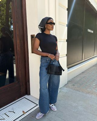 @nlmarilyn wearing a black tee, dark jeans, mesh flats, and a silk bandana.