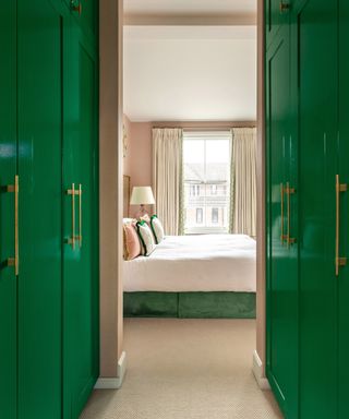 Lacquered green wardrobes illustrating small bedroom storage ideas.