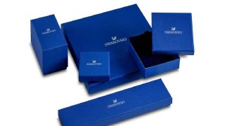 A variety of dark blue Swarovski jewellery boxes on a white background.