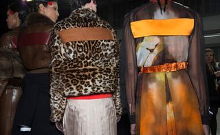 Shot of the back of 2 models showing orange outfit details