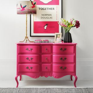 Pink chest of drawer with wall art
