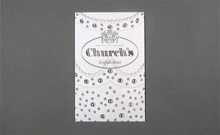 View of Church’s white embellished invitation pictured against a grey background