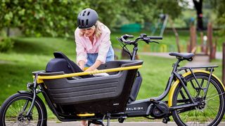 Woman settling baby in Raleigh Stride cargo e-bike