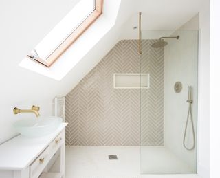 A bathroom with a shower and a sloped ceiling