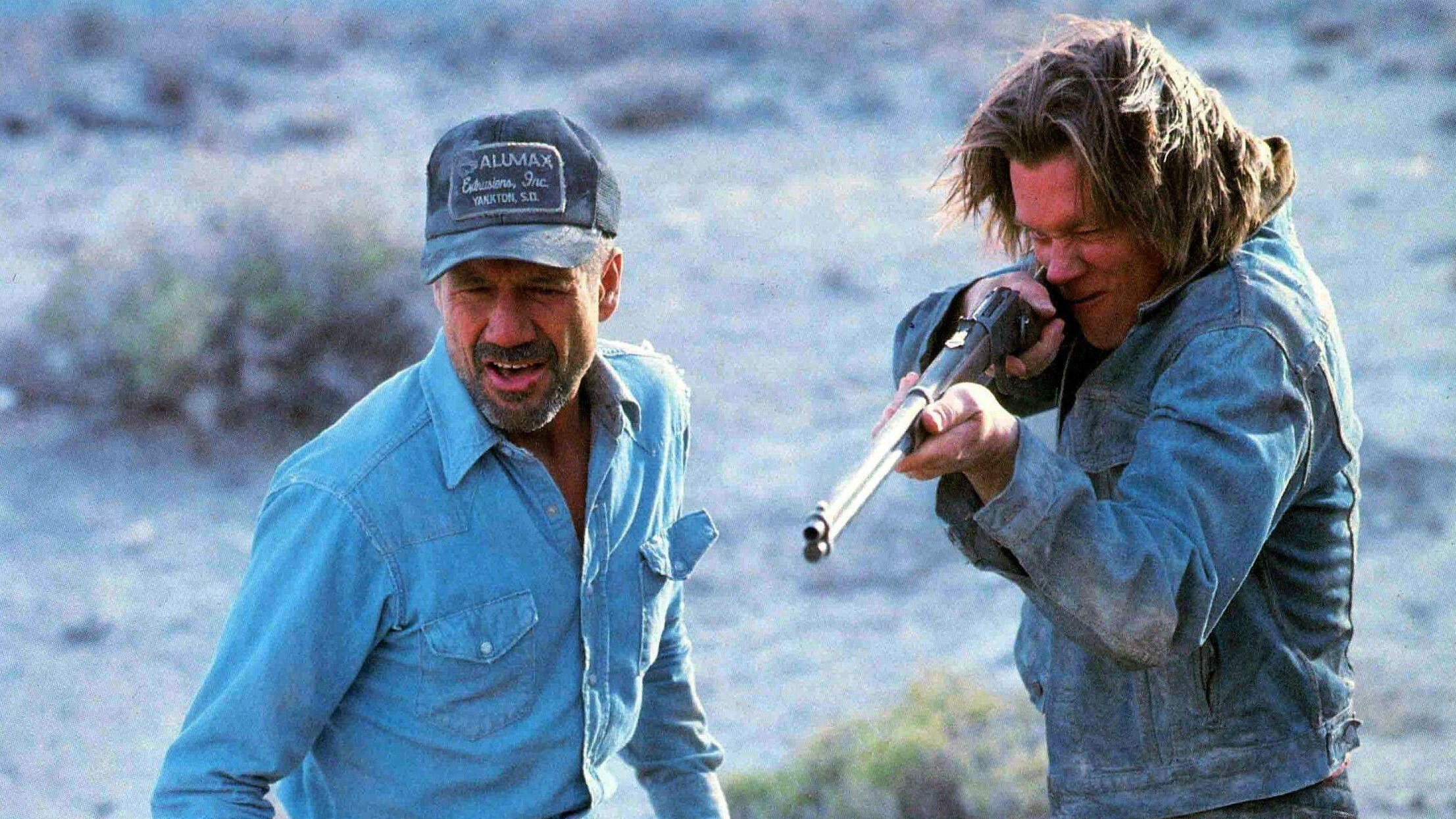 L-R Earl (Fred Ward) and Van (Kevin Bacon), who&#039;s brandishing a rifle, in a scene from &amp;quot;Tremors&amp;quot;