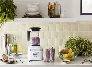 a KitchenAid blender blending a smoothie on worktop