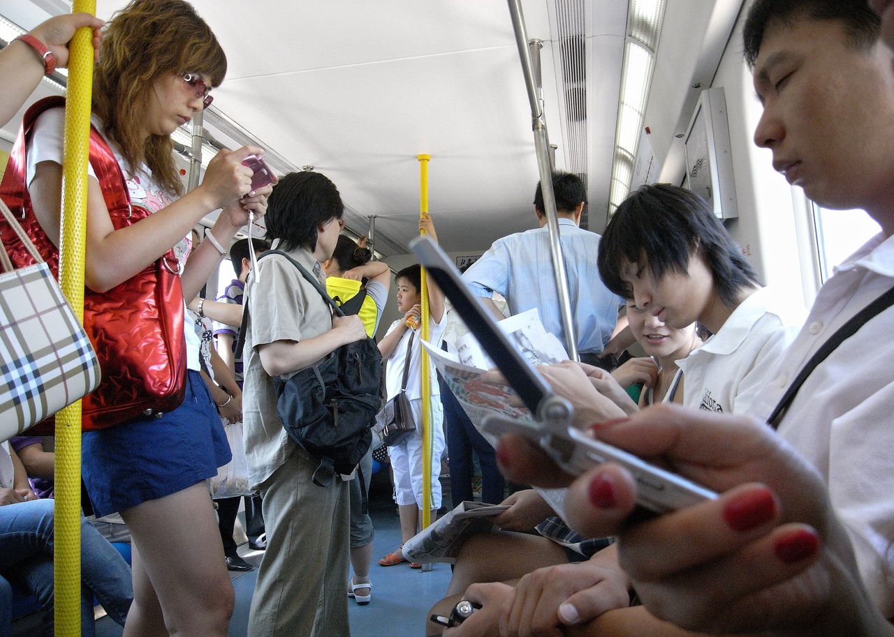 People check phones in Beijing 