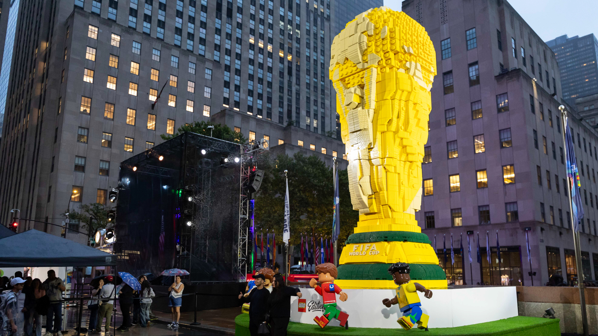 Fans pose for a photograph with the Lego Group and FIFA World Cup trophy at the Rockefeller Center