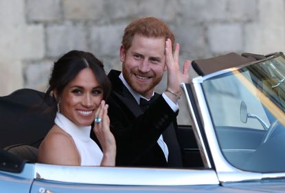 Duchess of Sussex and Prince Harry, Duke of Sussex wave as they leave Windsor Castle after their wedding to attend an evening reception at Frogmore House, hosted by the Prince of Wales on May