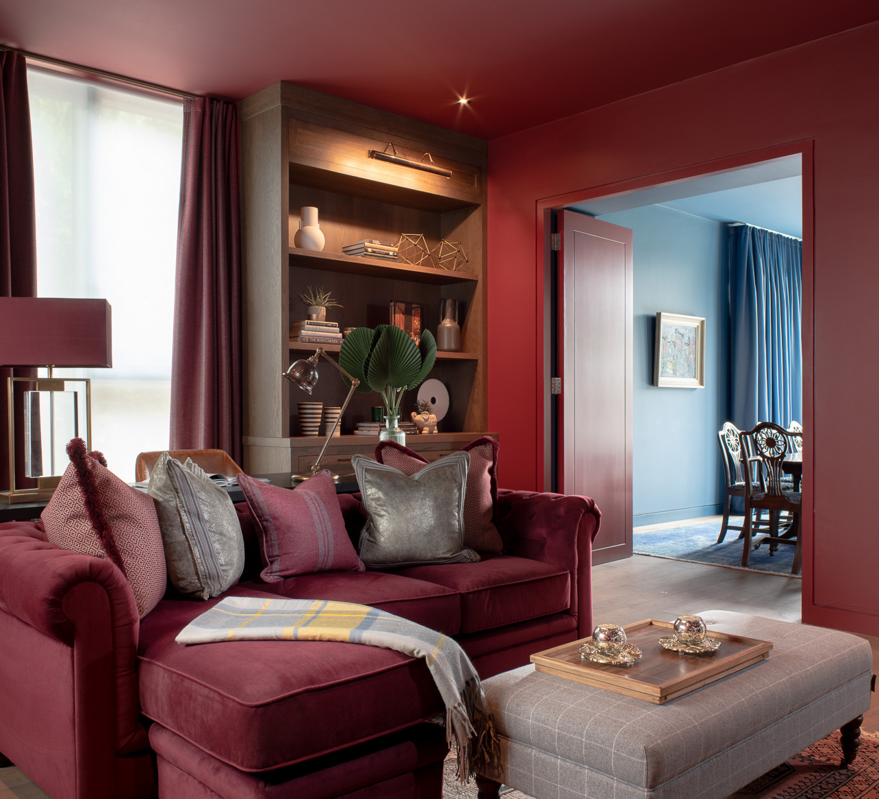 Red living room with red sofa, red walls and door and wood floor