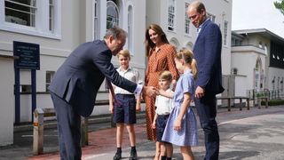 Prince George, Princess Charlotte and Prince Louis (C), accompanied by their parents the Prince William and Catherine, Princess of Wales are greeted by Headmaster Jonathan Perry as they arrive for a settling in afternoon at Lambrook School