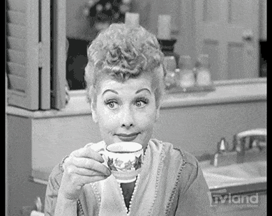 A woman sips a cup of tea.