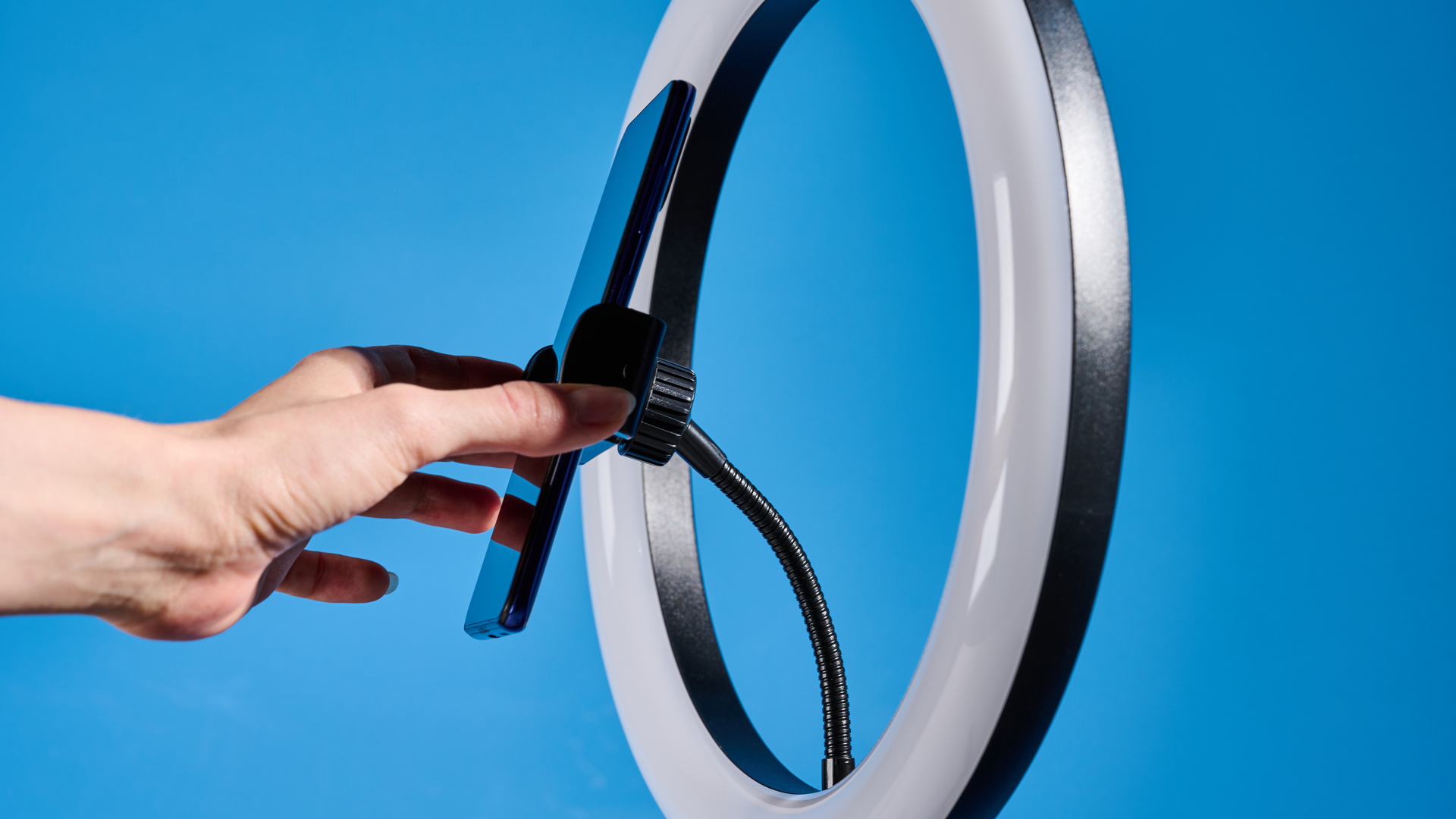 Godox 12-inch ring light photographed in front of a blue background with an iPhone on the phone mount.