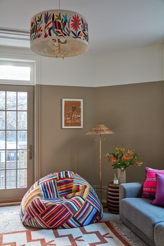 Family room with half beige and half white walls and colorful bean bag