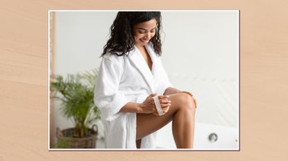 Image of woman in a white bath robe using an exfoliating mitt on her leg, in a white frame set against a warm beige watercolour-style background