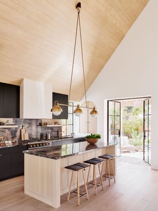 a kitchen with a large vaulted roof and hanging pendant light