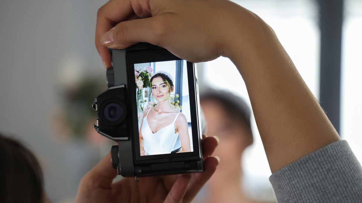 The back of a camera with a bride on the screen