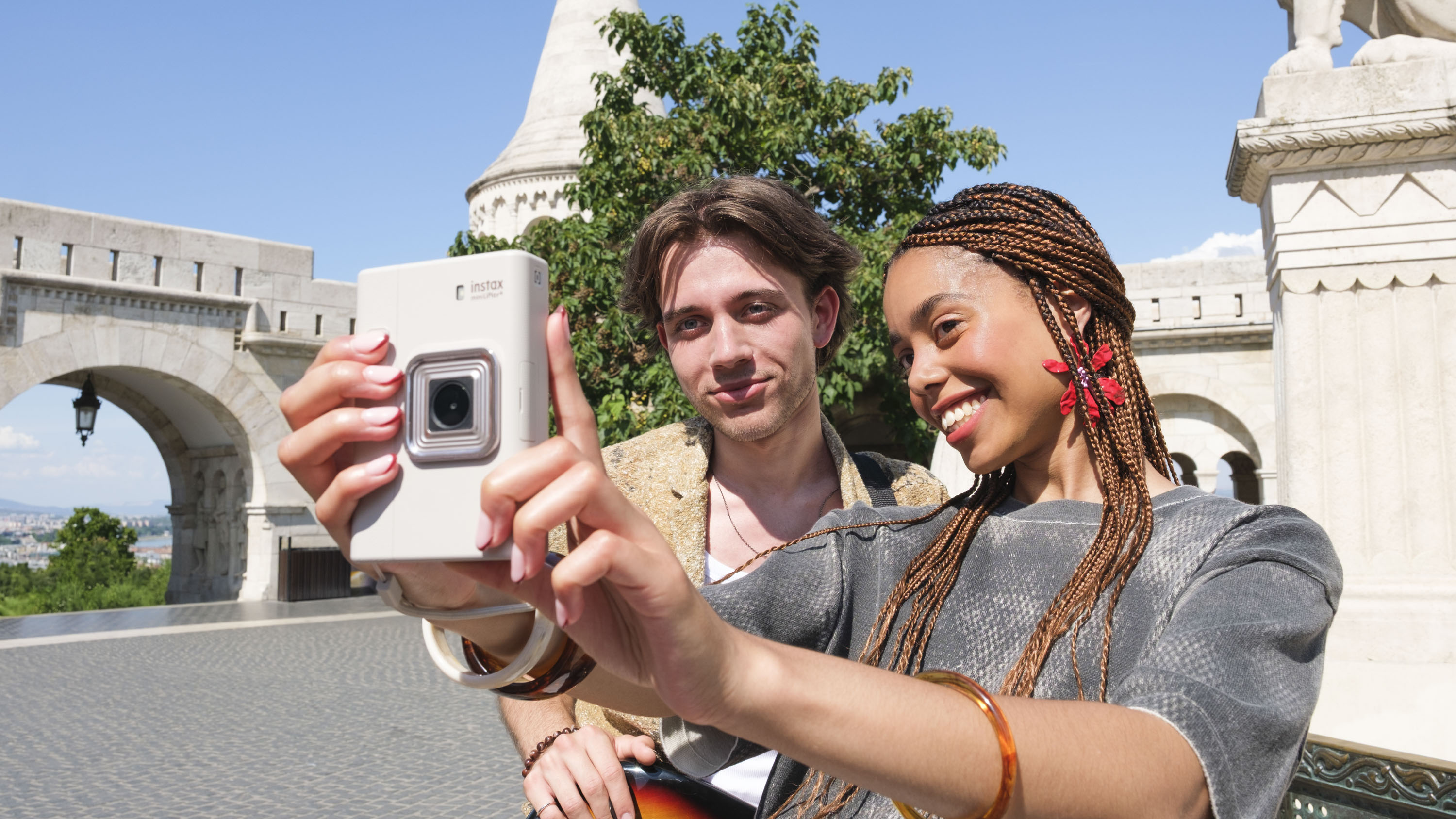 Woman taking a selife with the Fujifilm Instax mini LiPlay+ hybrid instant camera
