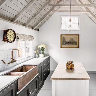 attic kitchen with white wall and clock on wall
