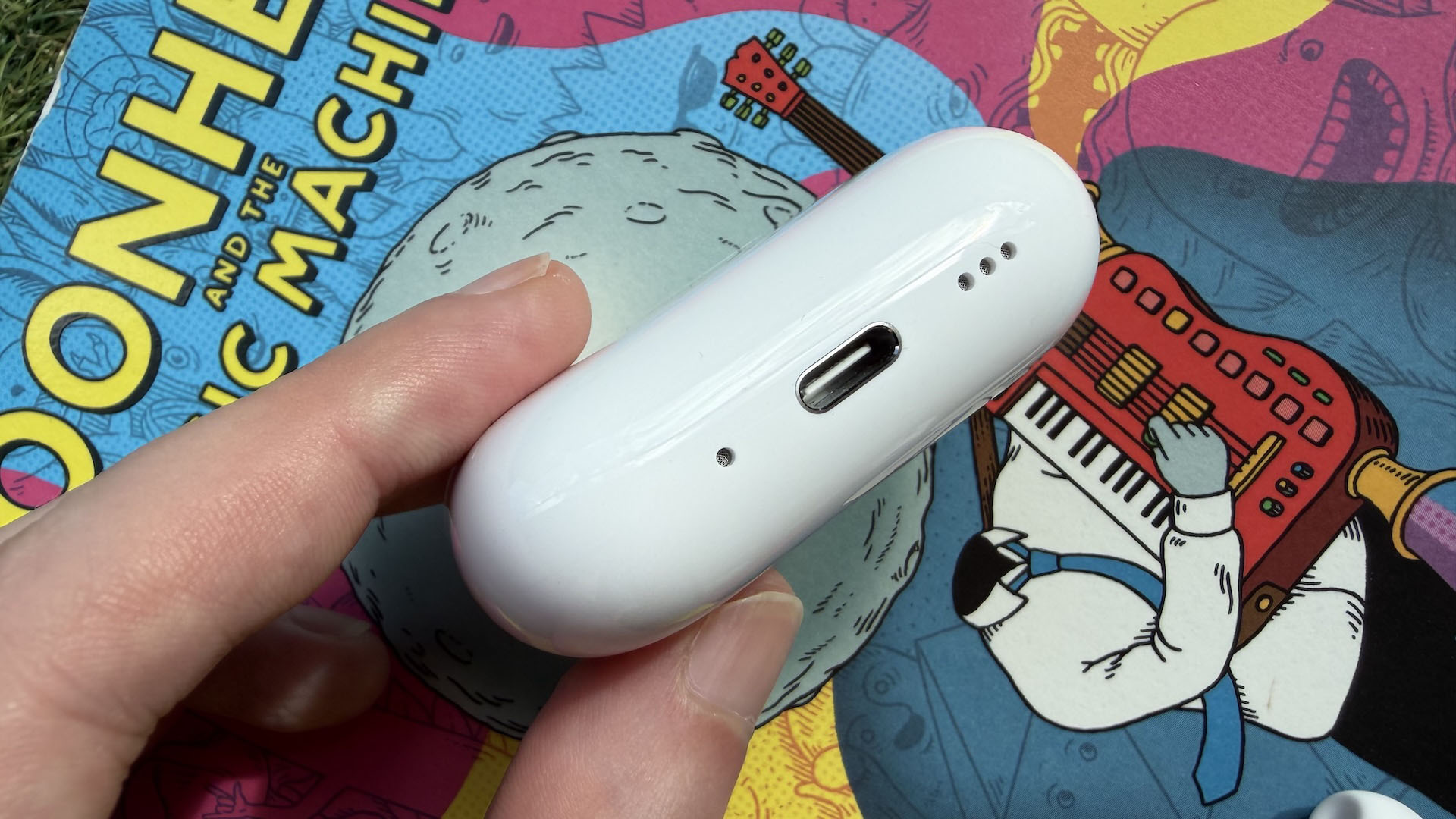 The AirPods Pro 3 earbuds from Apple against the pages of a graphic novel.