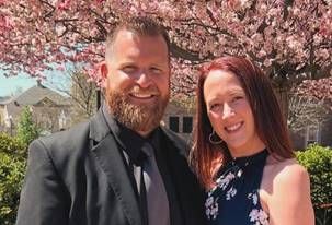 Smiling headshot of Peter Melvin with a woman in front of cherry blossoms.