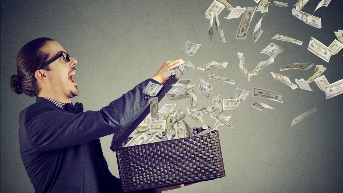 A businessman opening a box of flying money to symbolise corporate spending