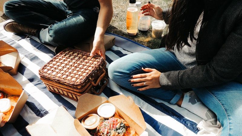 couple sitting on blanket with picnic basket